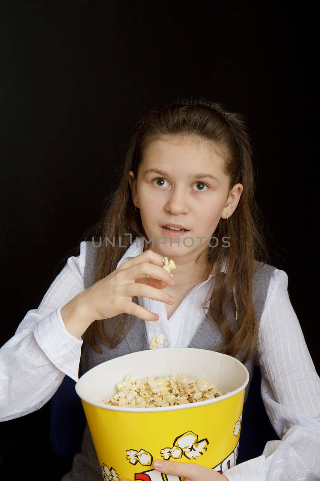 emotional girl with popcorn on a black background
