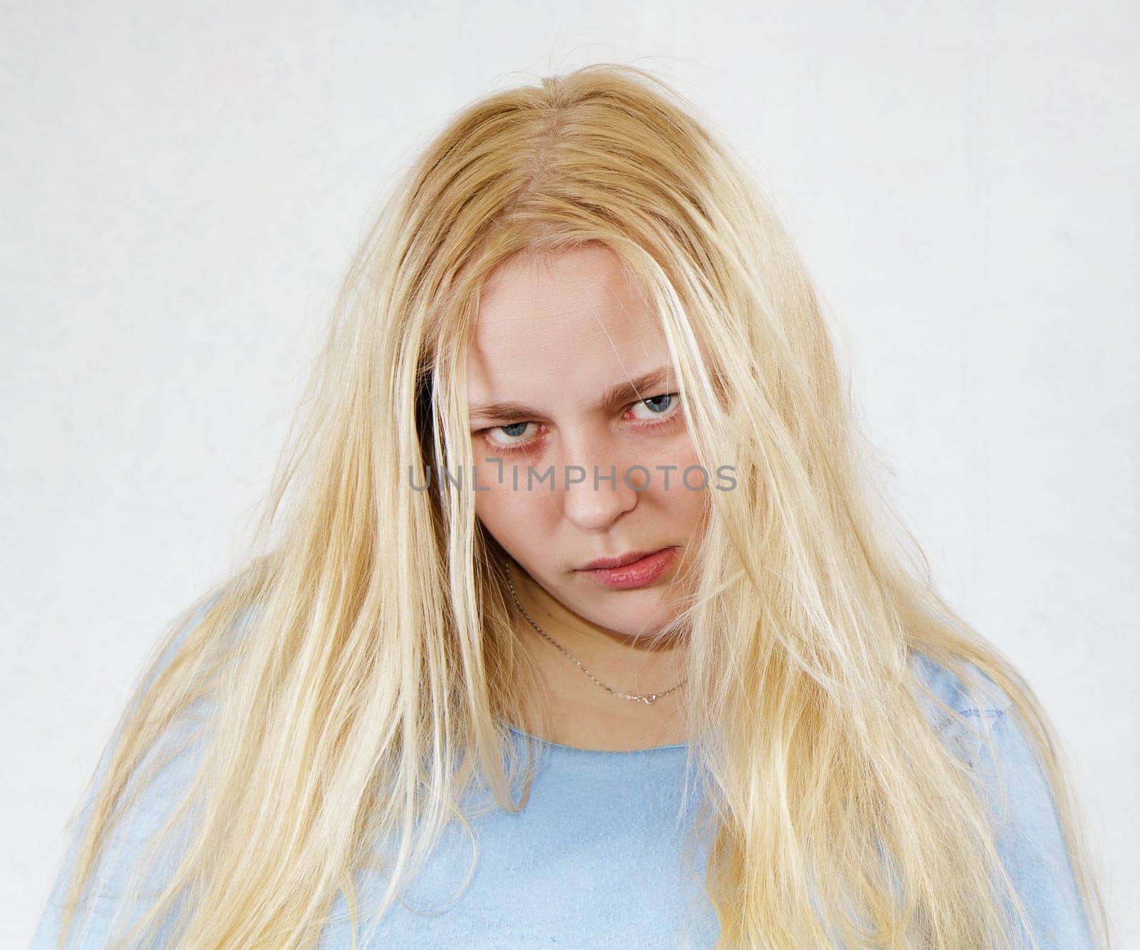 crazy disheveled woman in a blue shirt on a white background