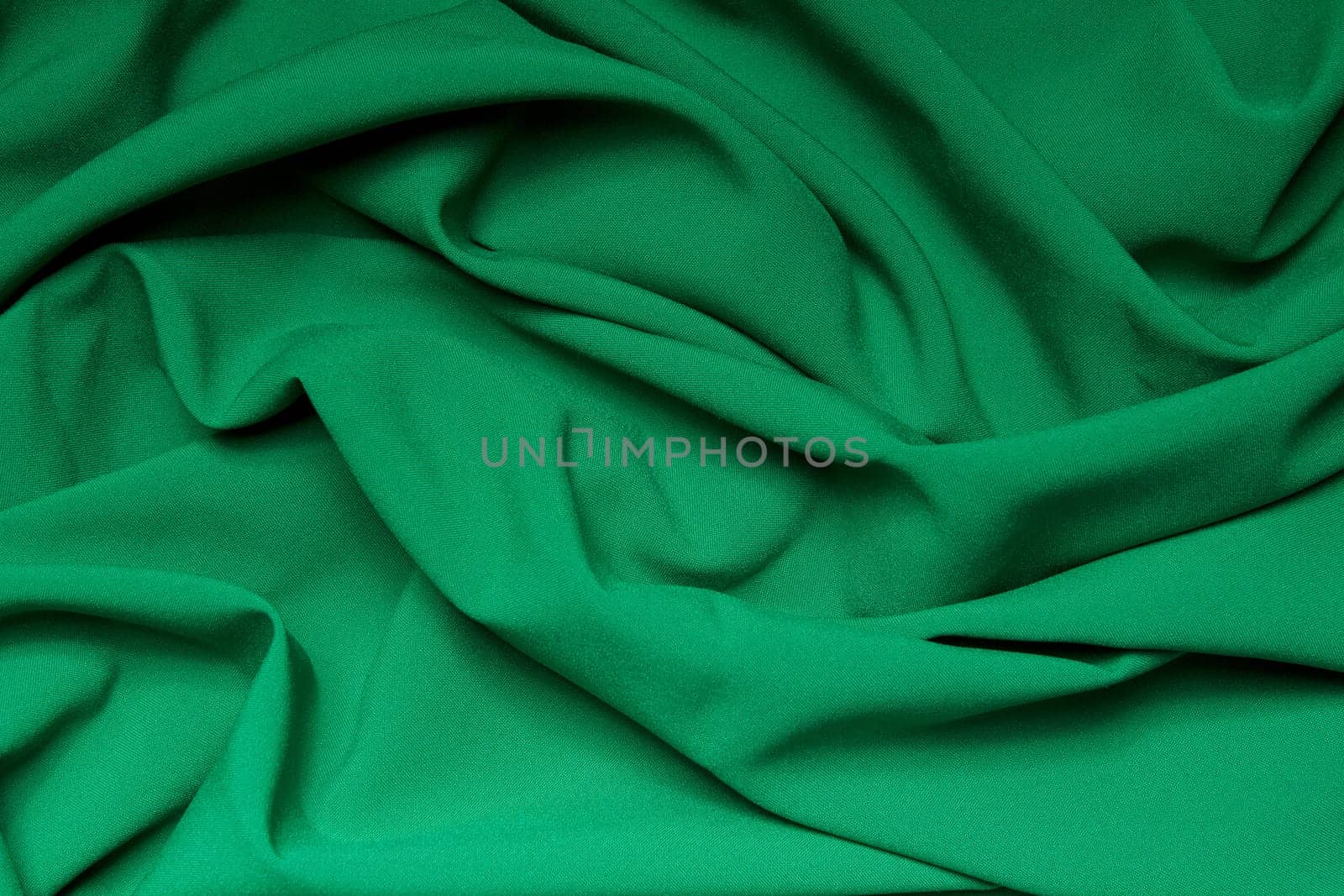 The folds of a bright green cloth. Abstract Background