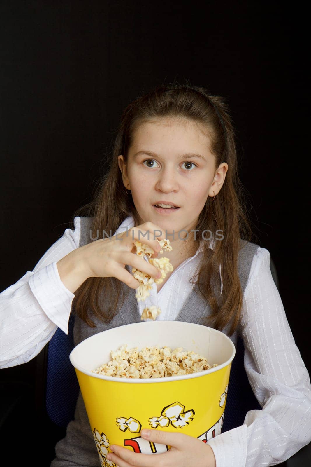 emotional girl with popcorn on a black background
