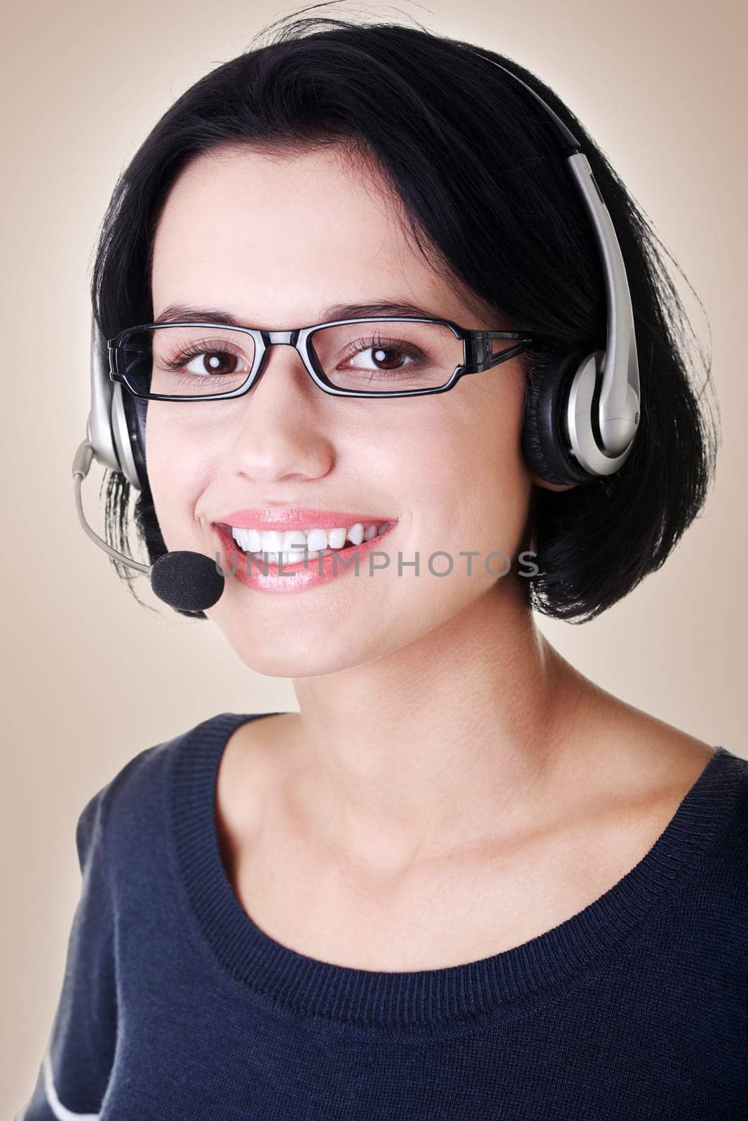 closeup of attractive customer support representative smiling with headset on brown background