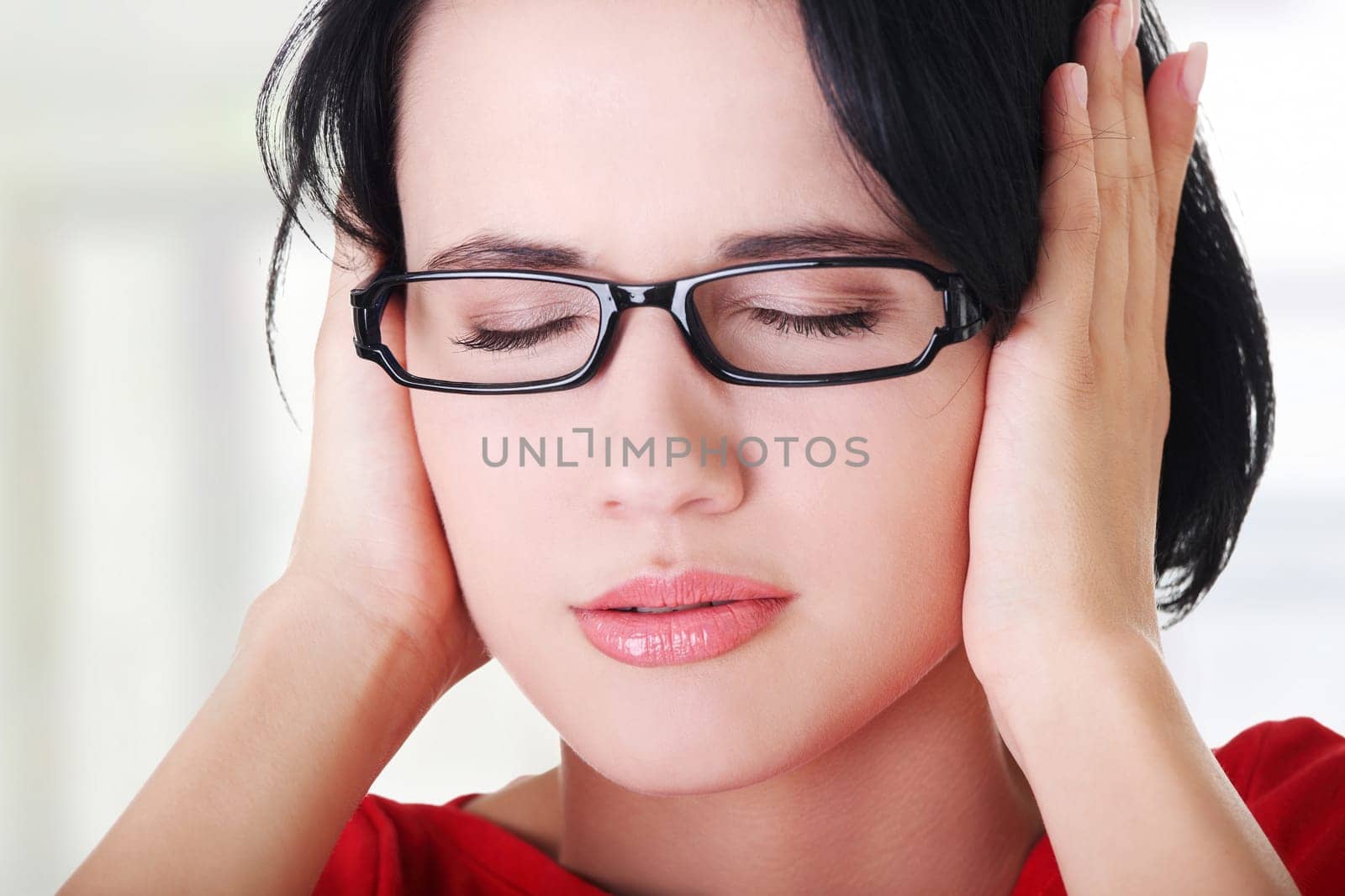closeup of frustrated young woman holding her ears