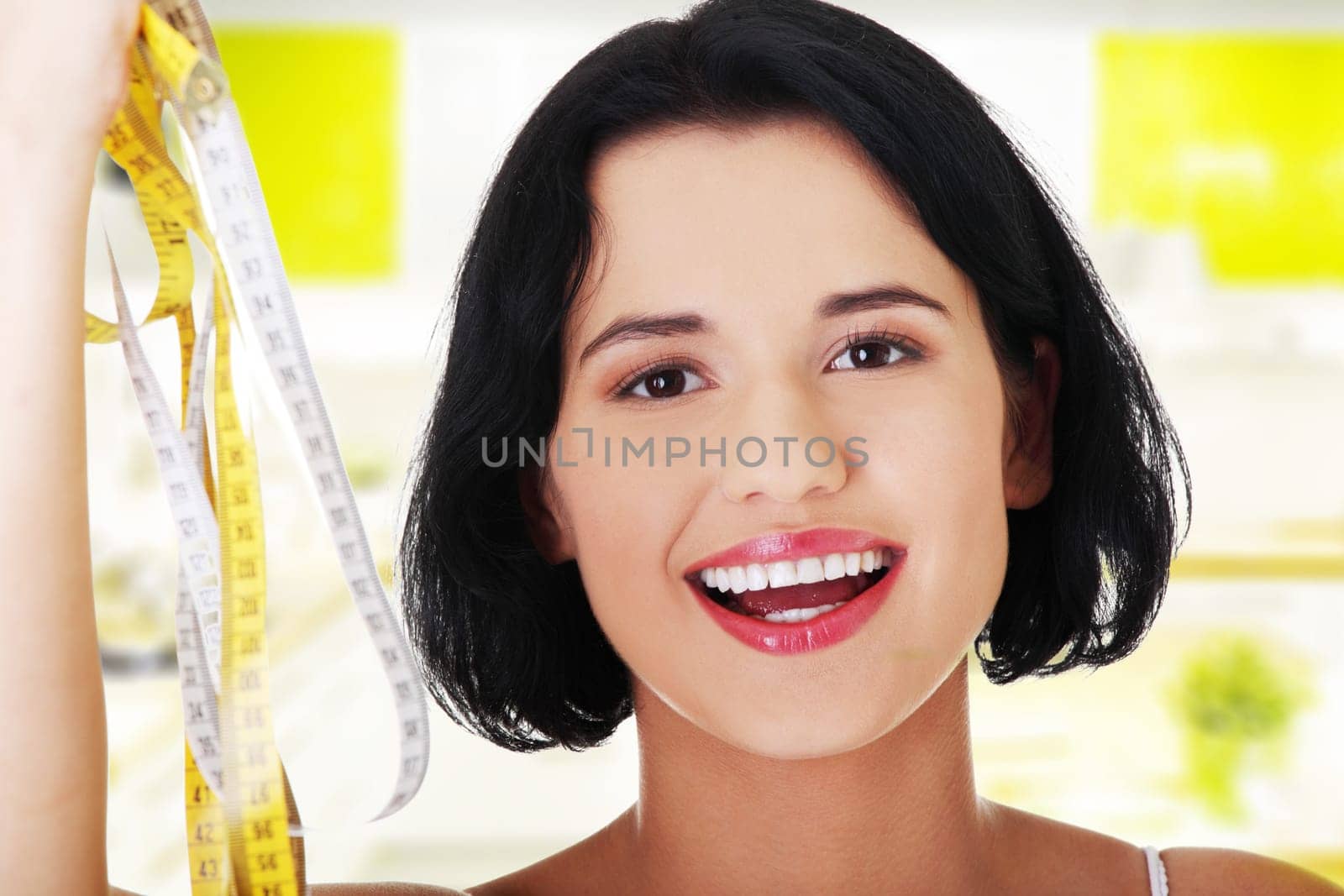Pretty smiling woman holding measurement types