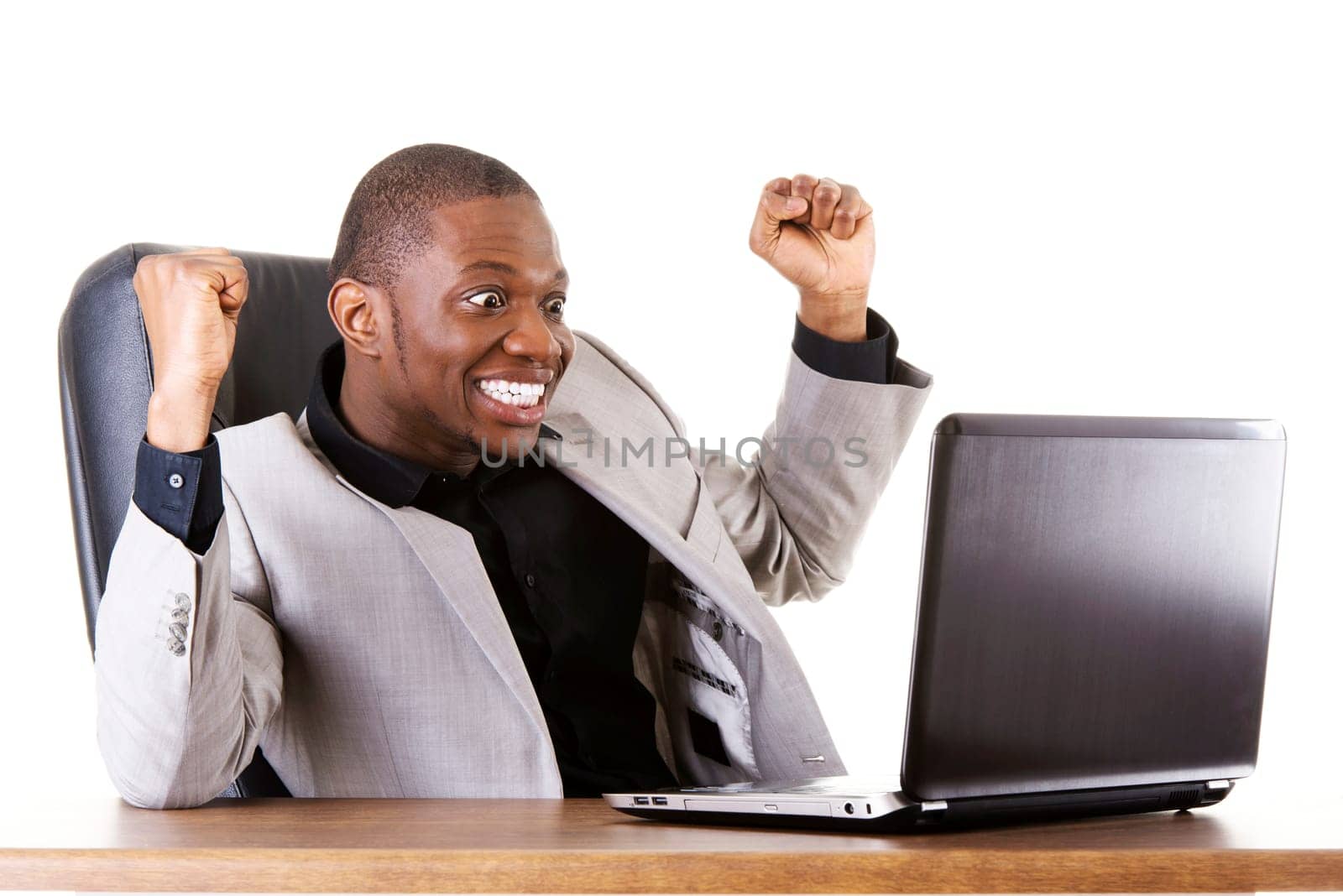 Happy successful businesman at the desk. Isolated on white.