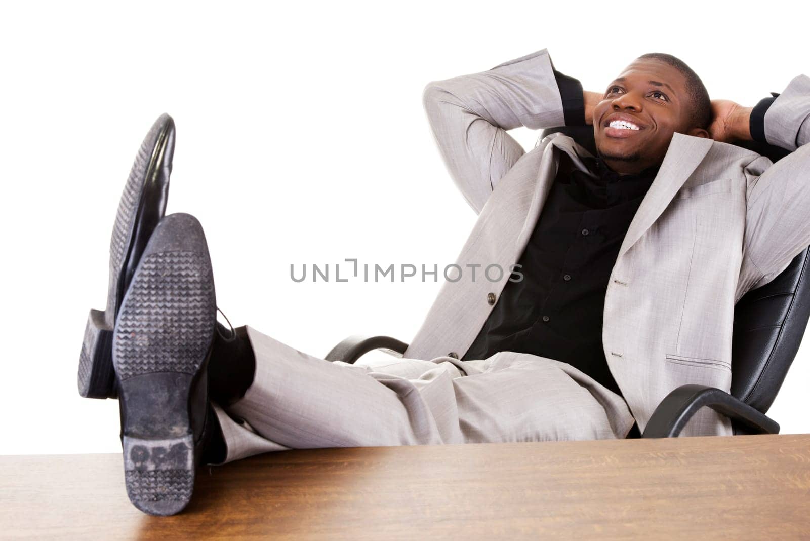 Happy successful businesman at the desk. Isolated on white.