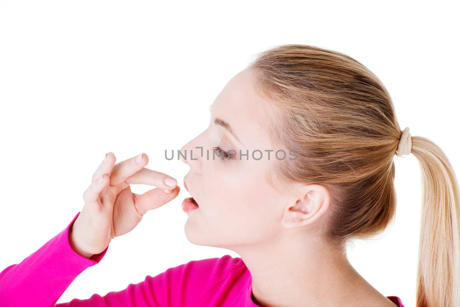 Blond woman taking pill, isolated on white.