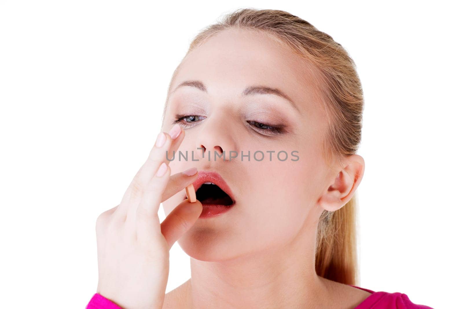 Blond woman taking pill, isolated on white.