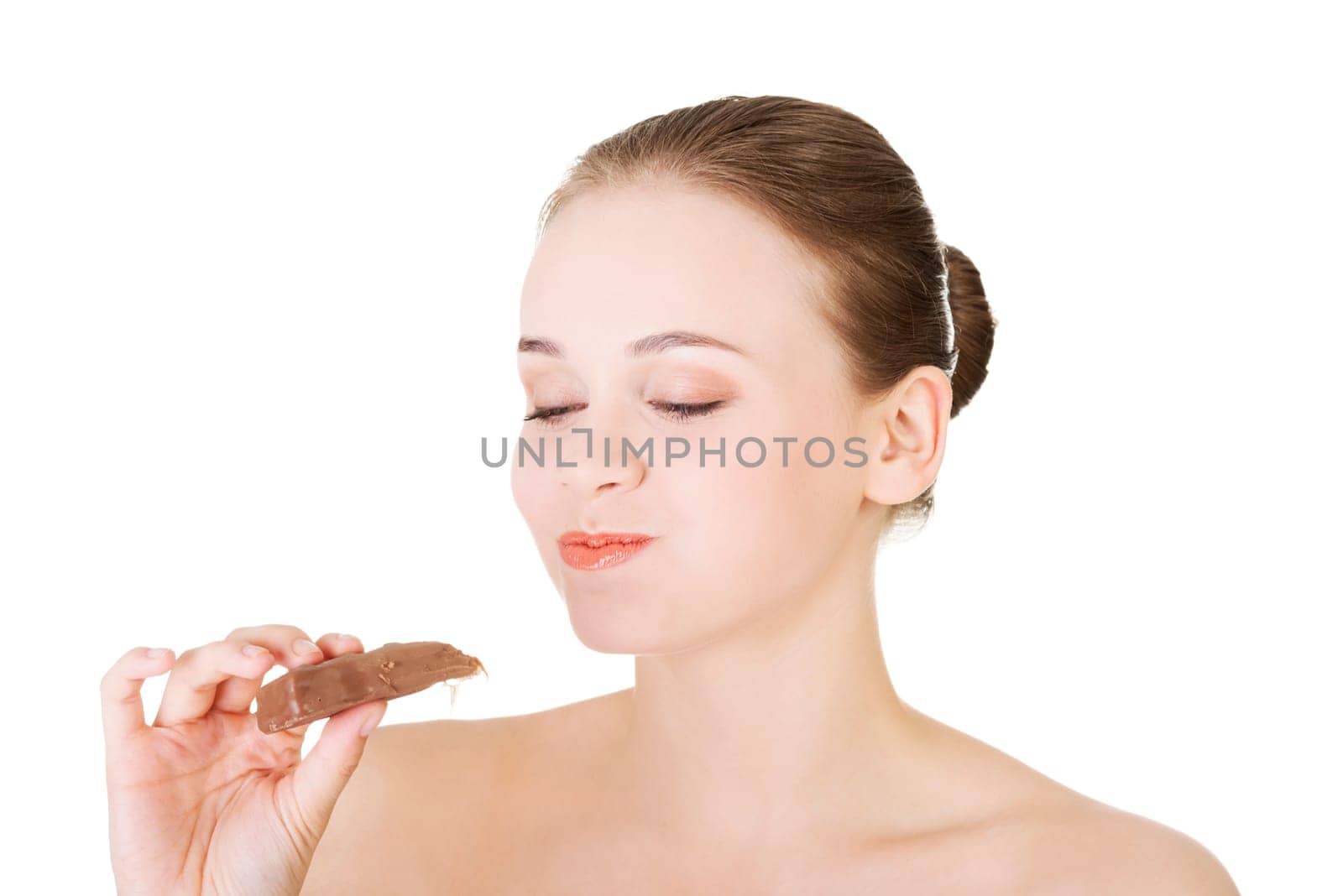 Beautiful woman biting a chocolate bar. Isolated on white