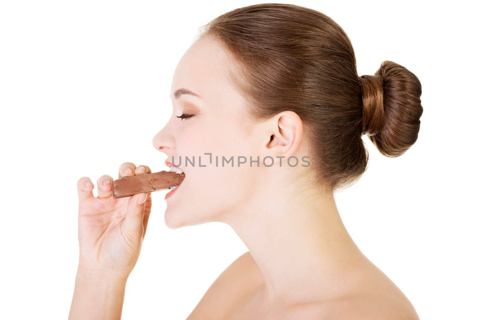 Beautiful woman biting a chocolate bar. Isolated on white