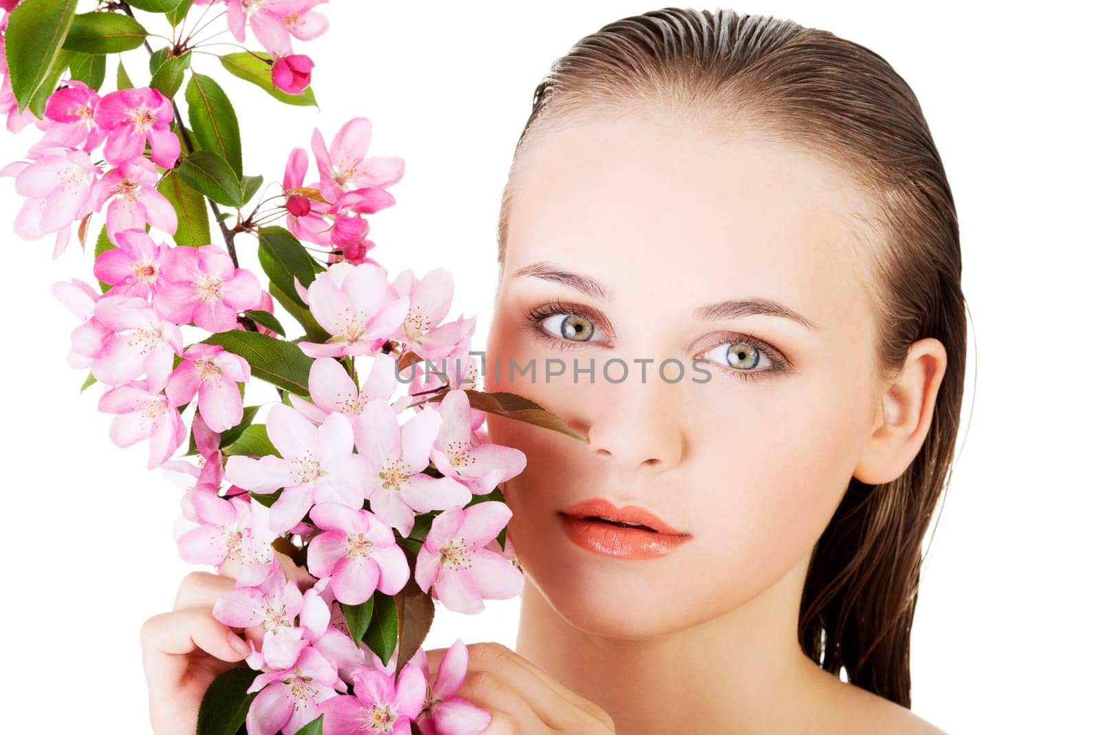 Beautiful face of spa woman with healthy clean skin and pink flowers. Isolated on white.