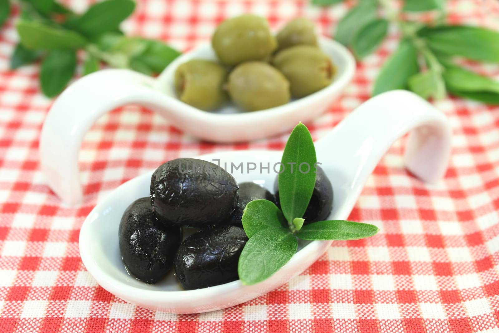 Olives with olive leaf on a spoon