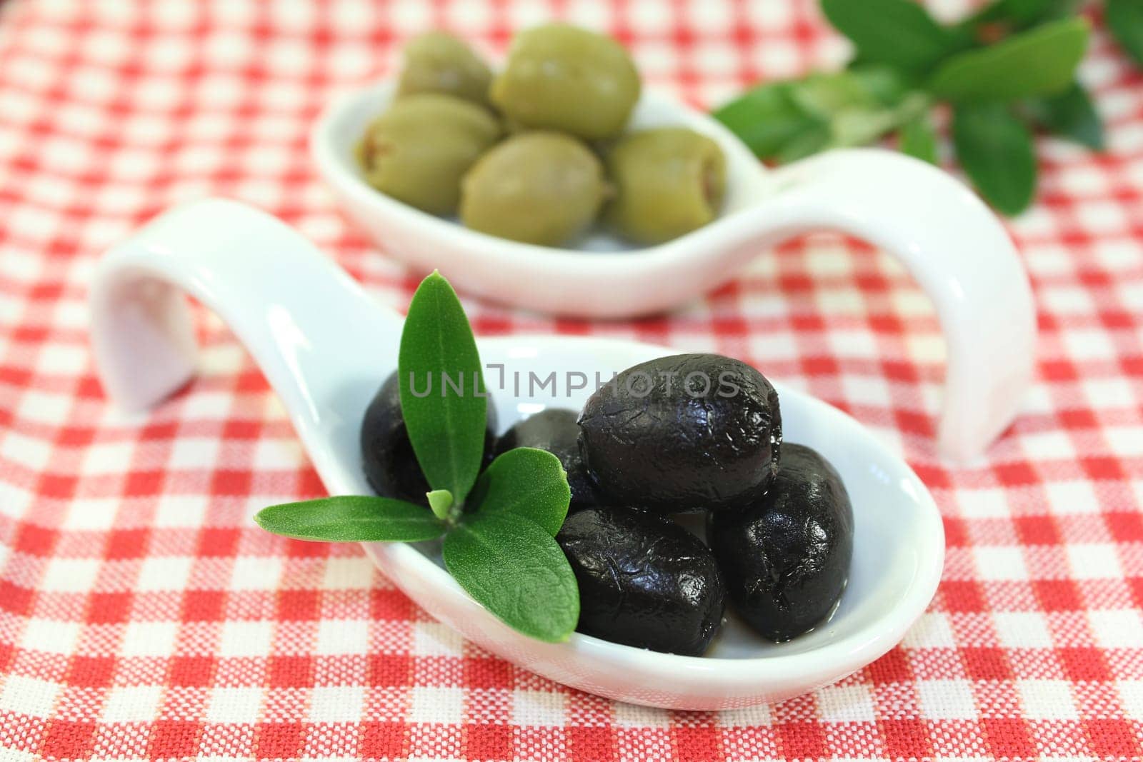 Olives with olive leaf on a spoon