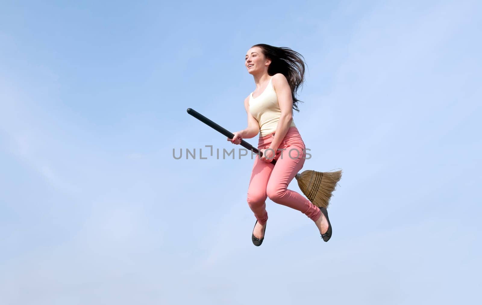 young woman flies with broom