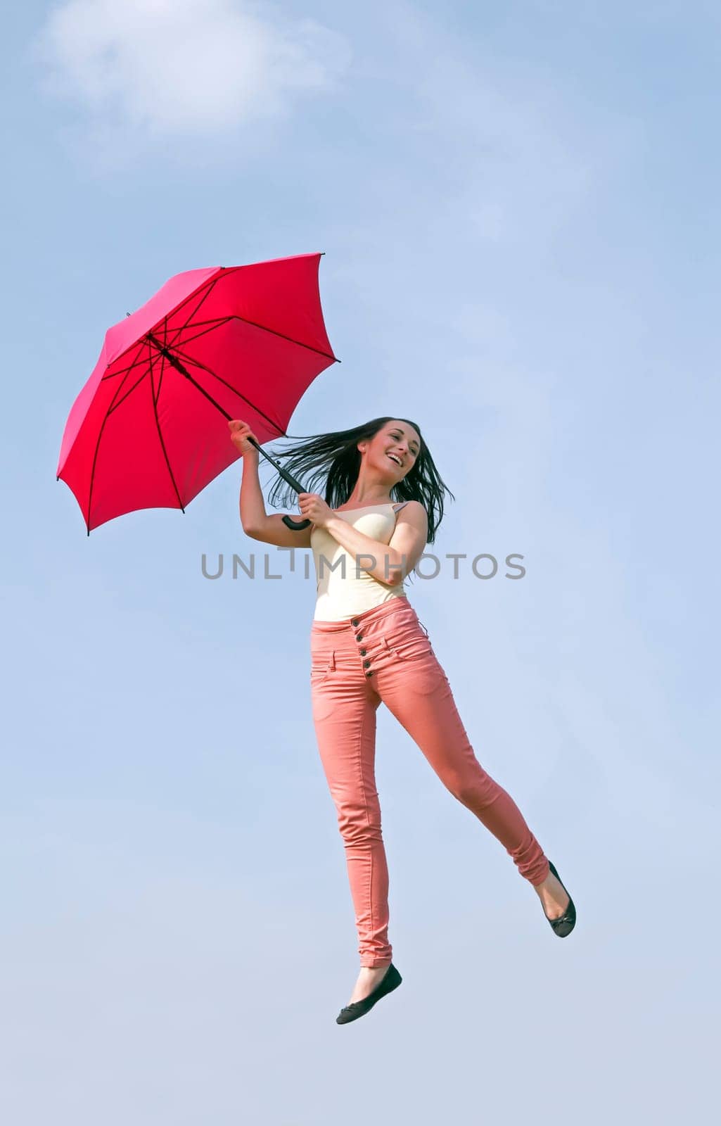 Woman jumps with umbrella