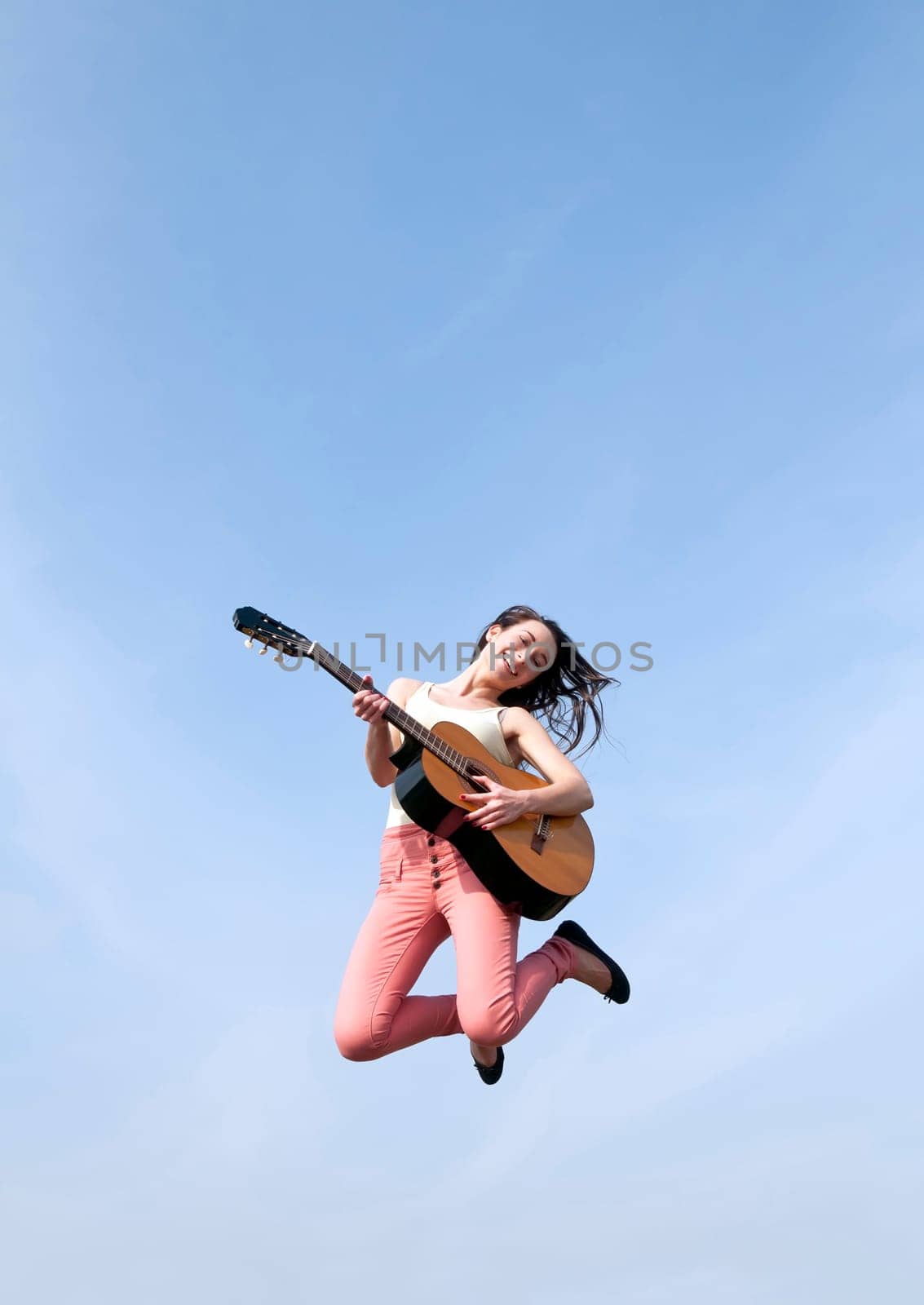 Woman jumps with guitar