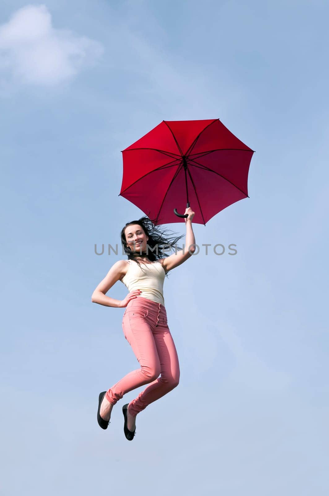 Woman jumps with umbrella
