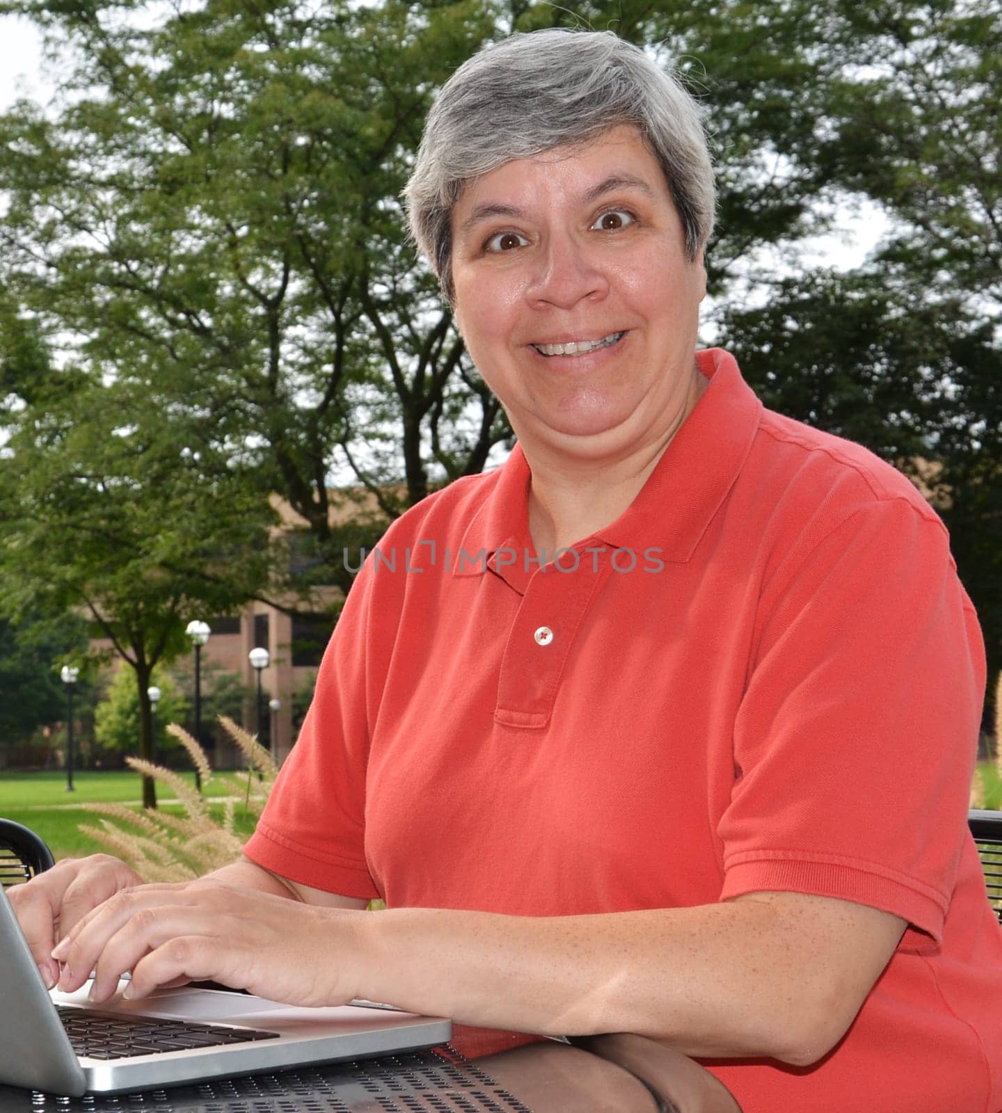Happy middle-aged woman at table with laptop