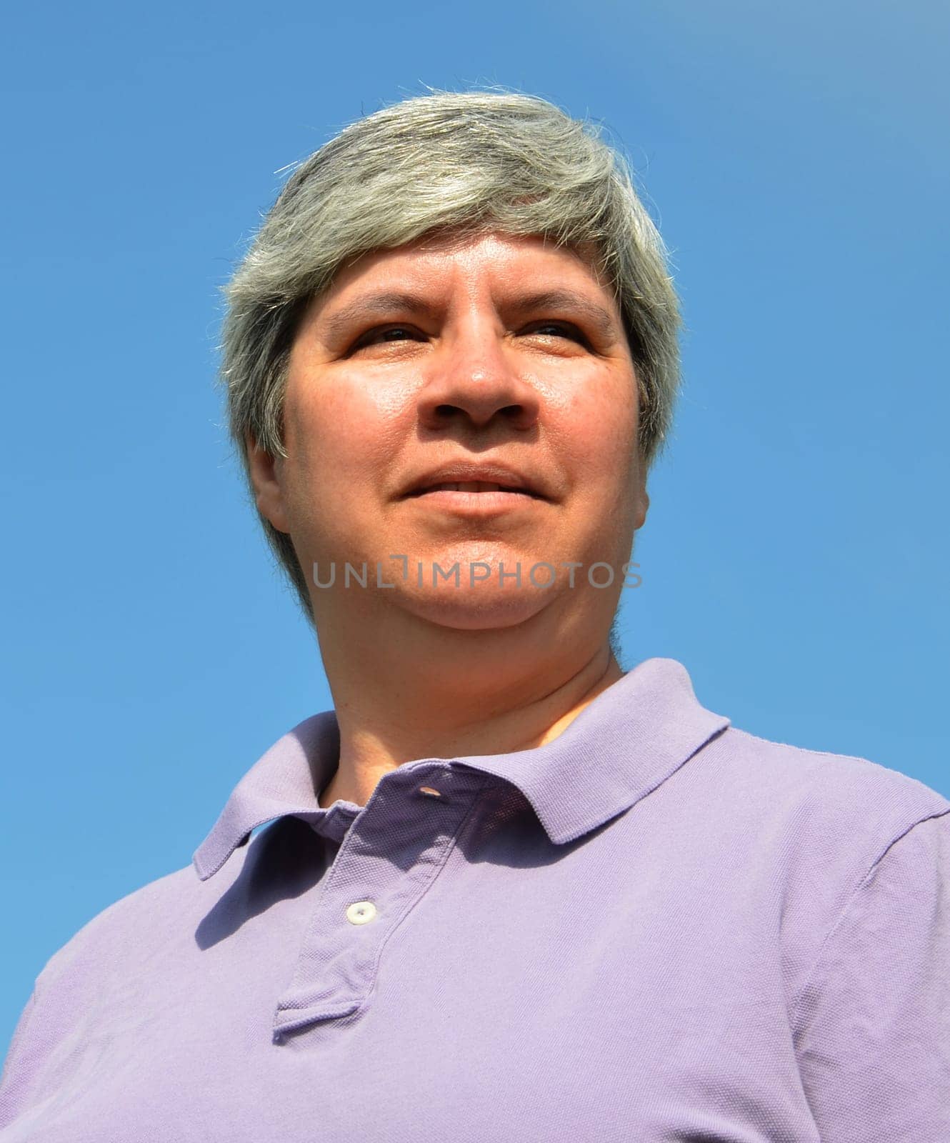 Older woman looking forward, sky in background