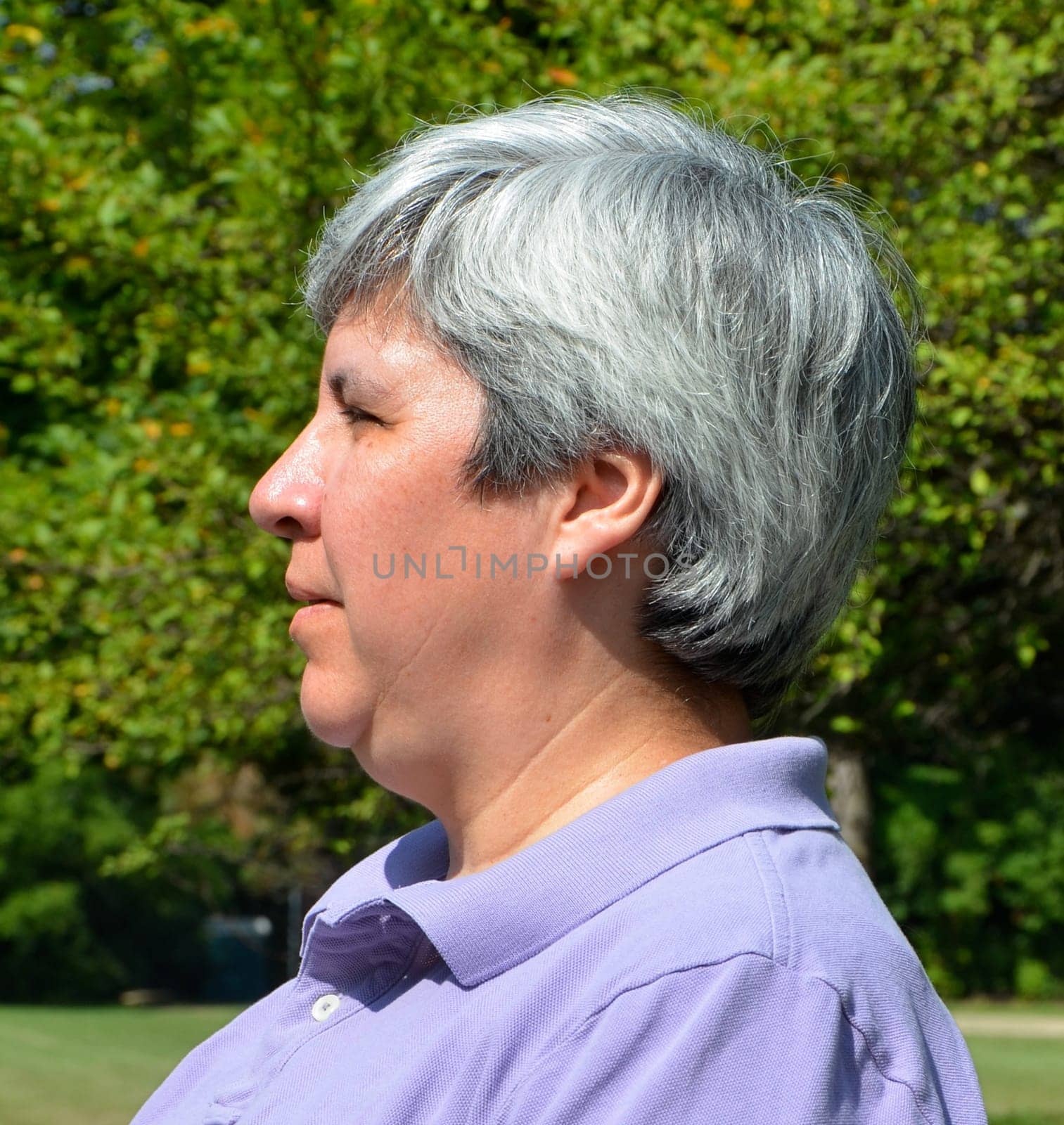 Older woman sitting on bench, profile view