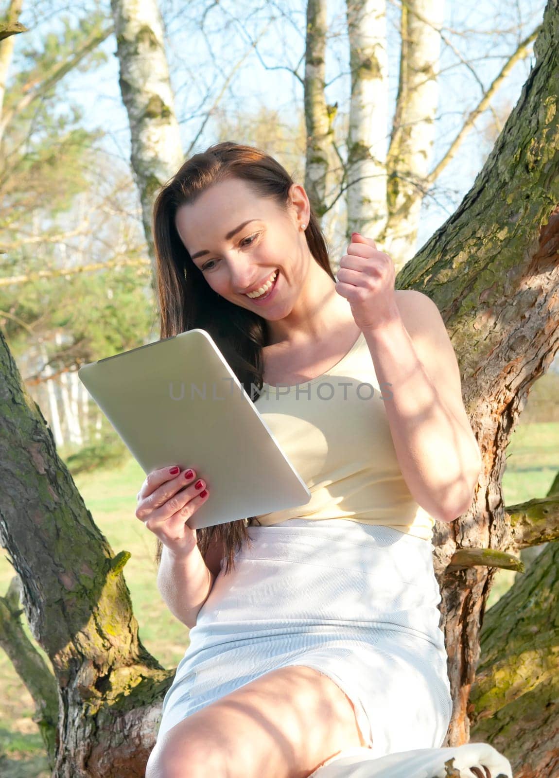 cheering woman with tablet pc