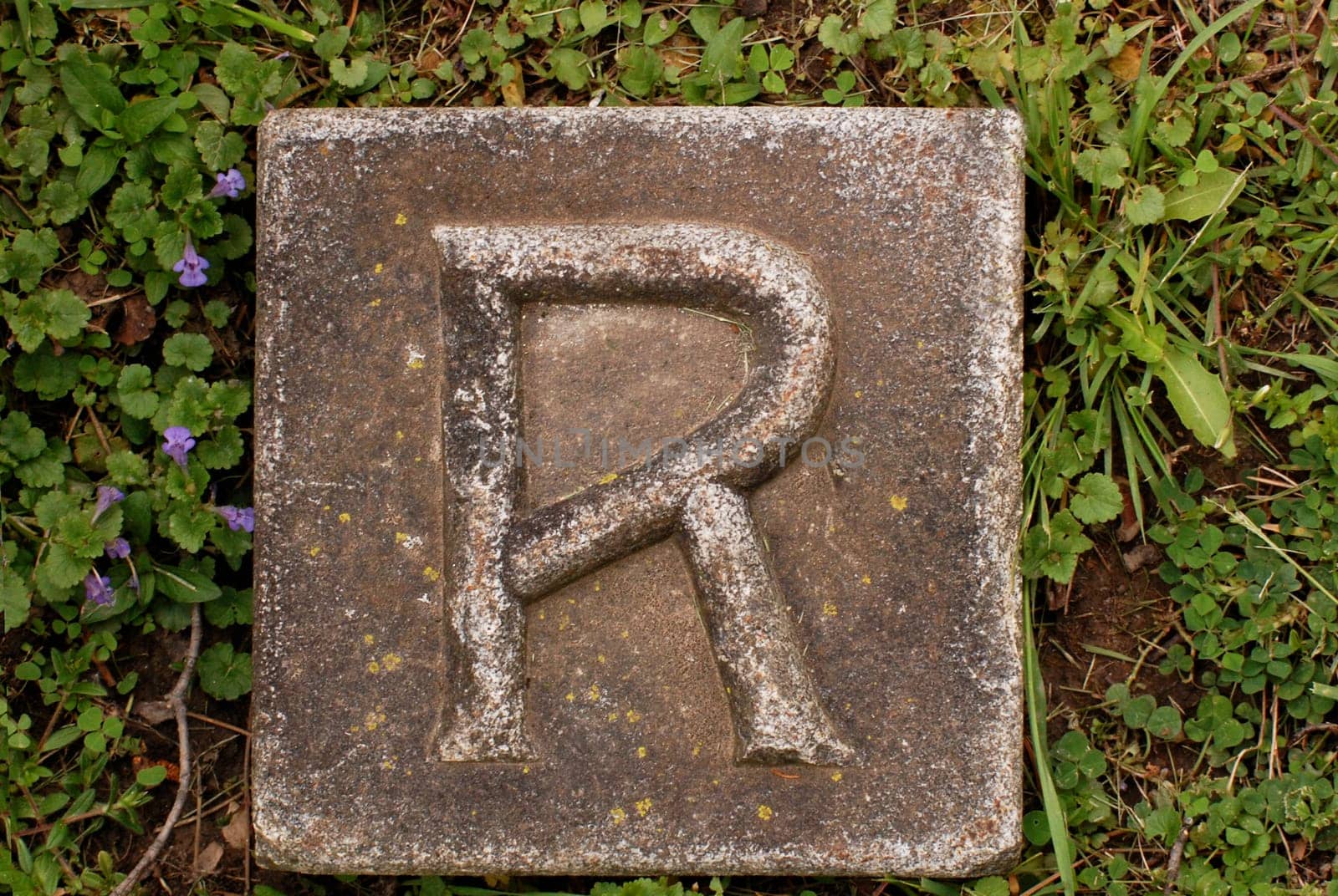 Block with letter R stone, in ground