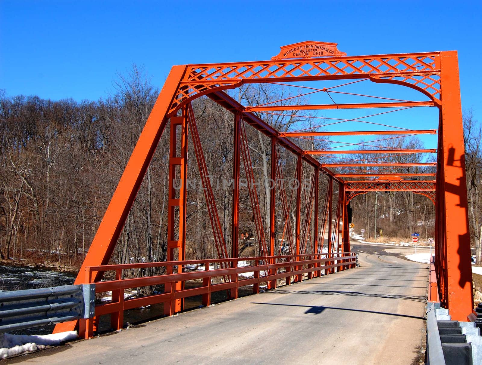 Wrought iron bridge over river, road view