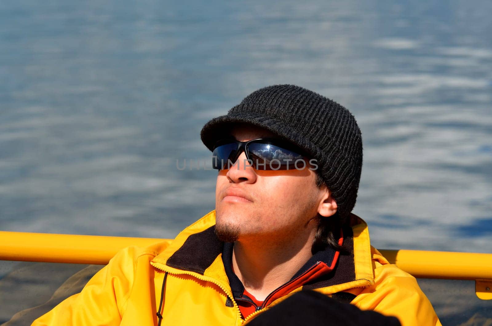 young man in sunglasses relaxing on boat