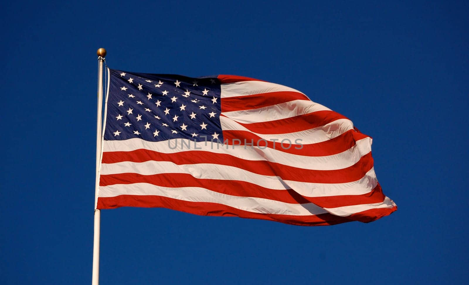 American flag flapping, with clear sky background, horizontal
