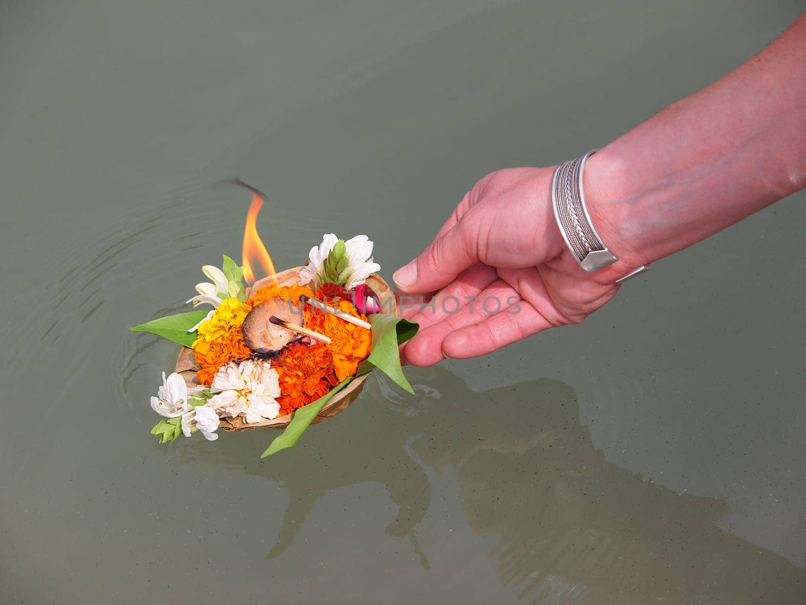 arangement of flowers and candle on the ganges river