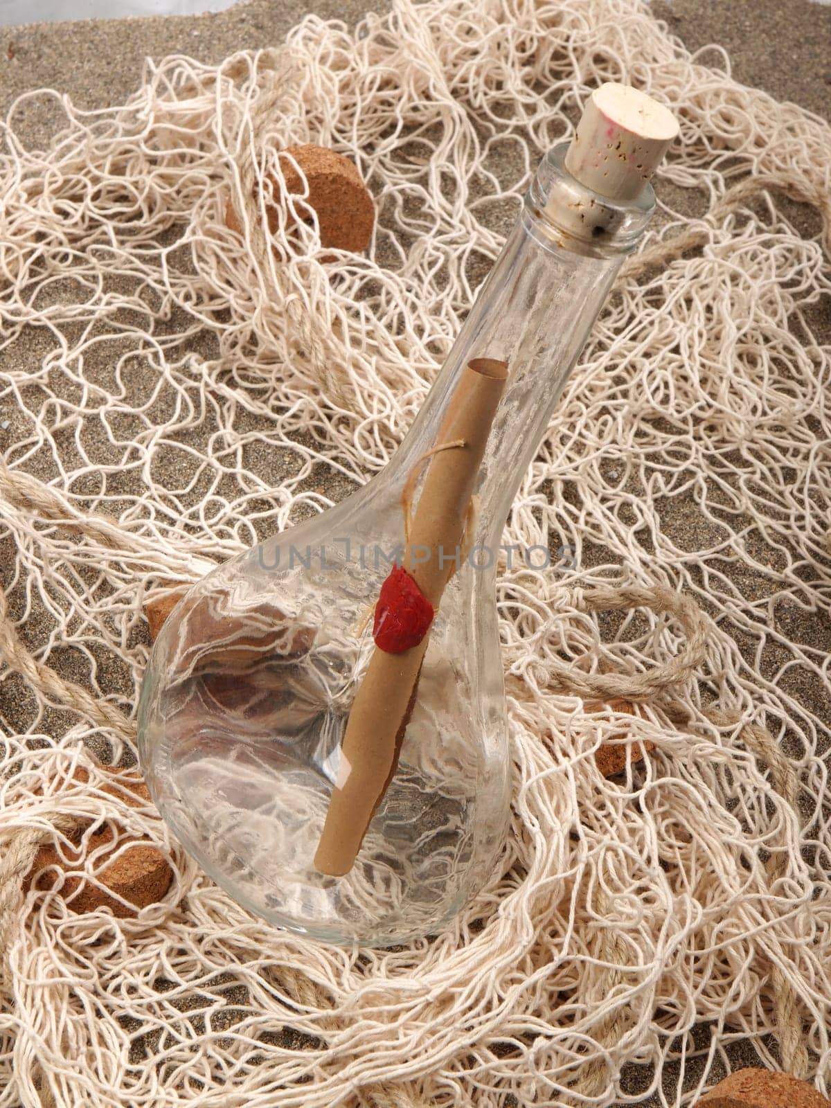 message in the bottle in the fishing net on the sand beach