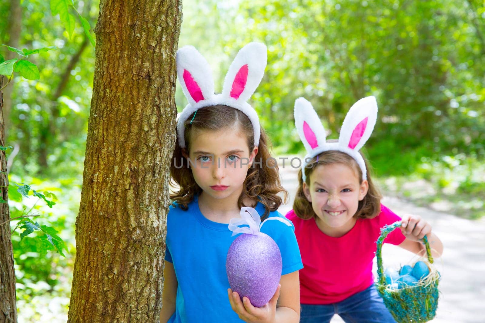 Easter girls playing on forest with bunny teeth expression outdoor