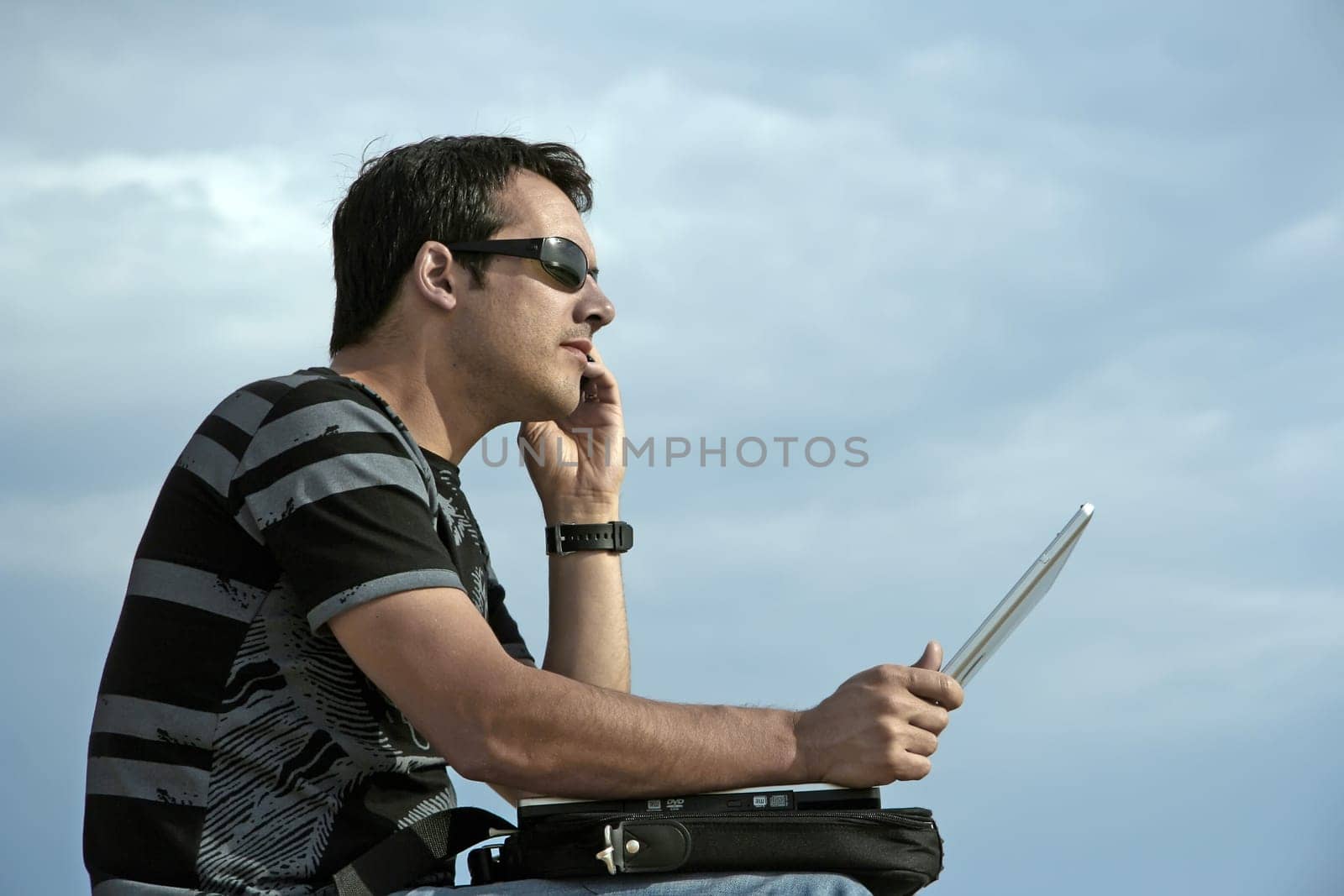 young man working on his laptop on the beach
