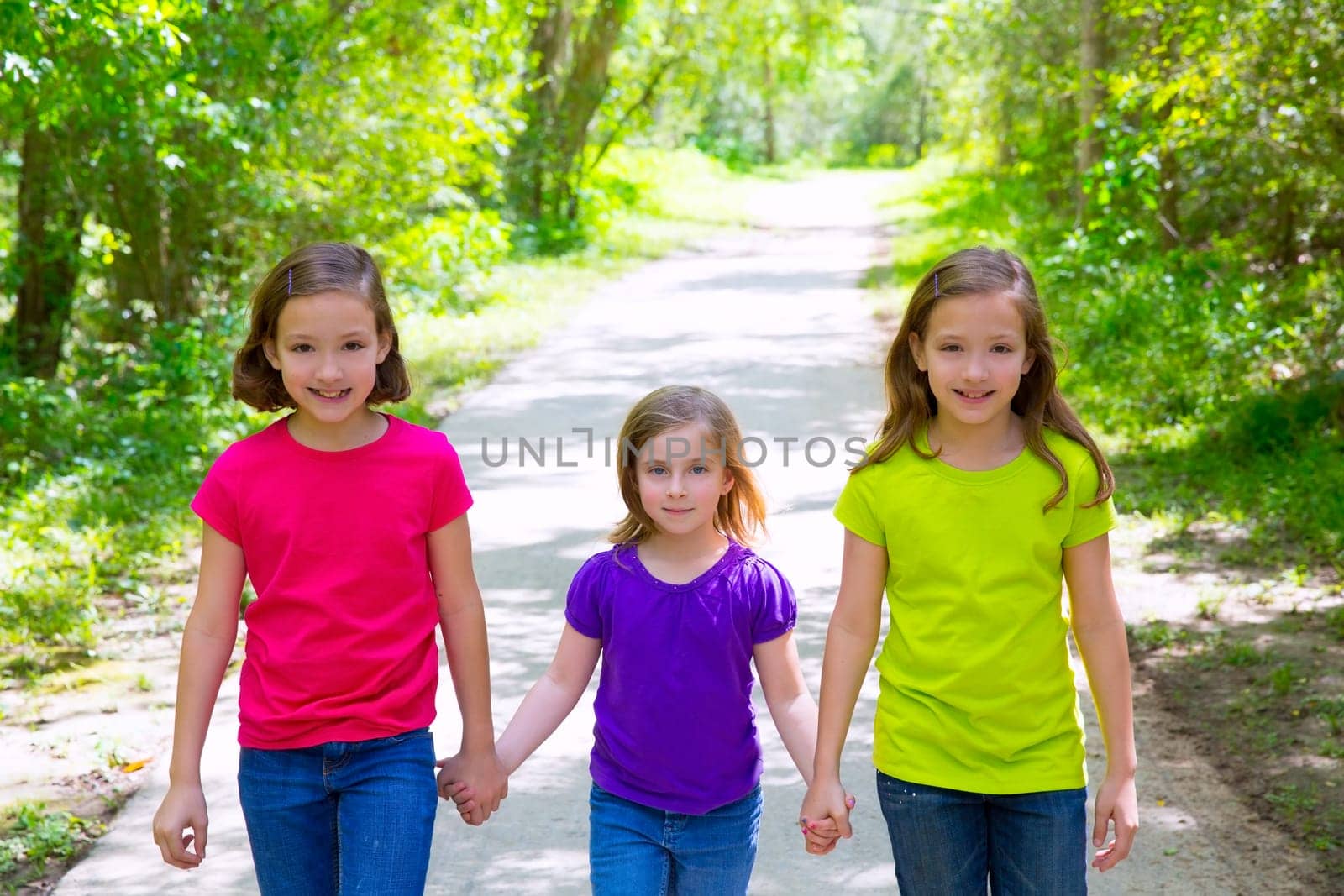 Friends and sister girls walking outdoor in forest track excursion