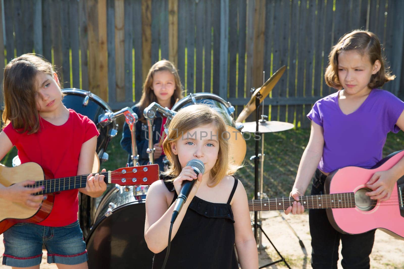 Blond kid singer girl singing playing live band in backyard concert with friends