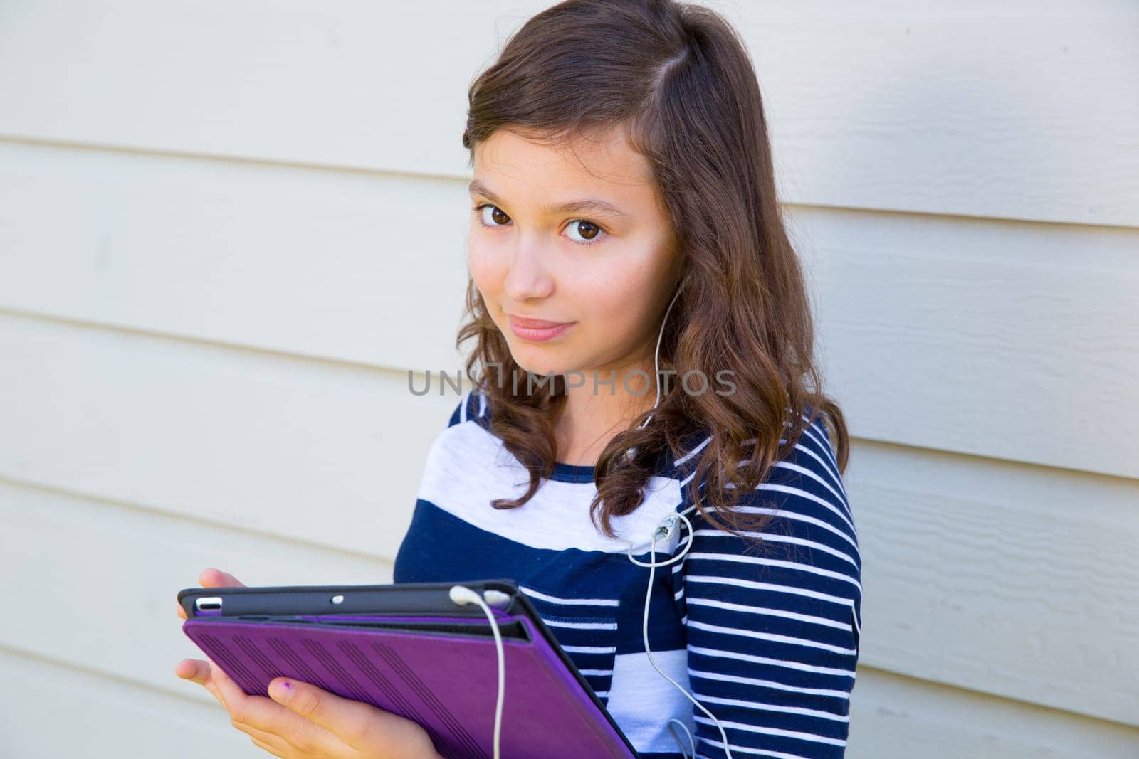 Teen girl happy holding tablet pc and earings smiling