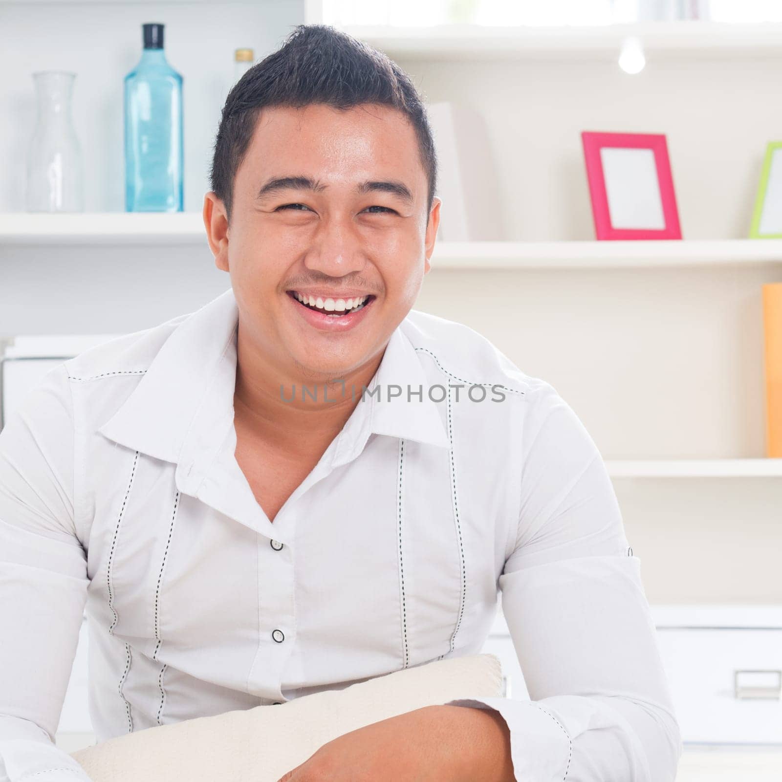 Good looking young Asian man smiling happy. Lifestyle Southeast Asian man at home. Handsome Asian male model.