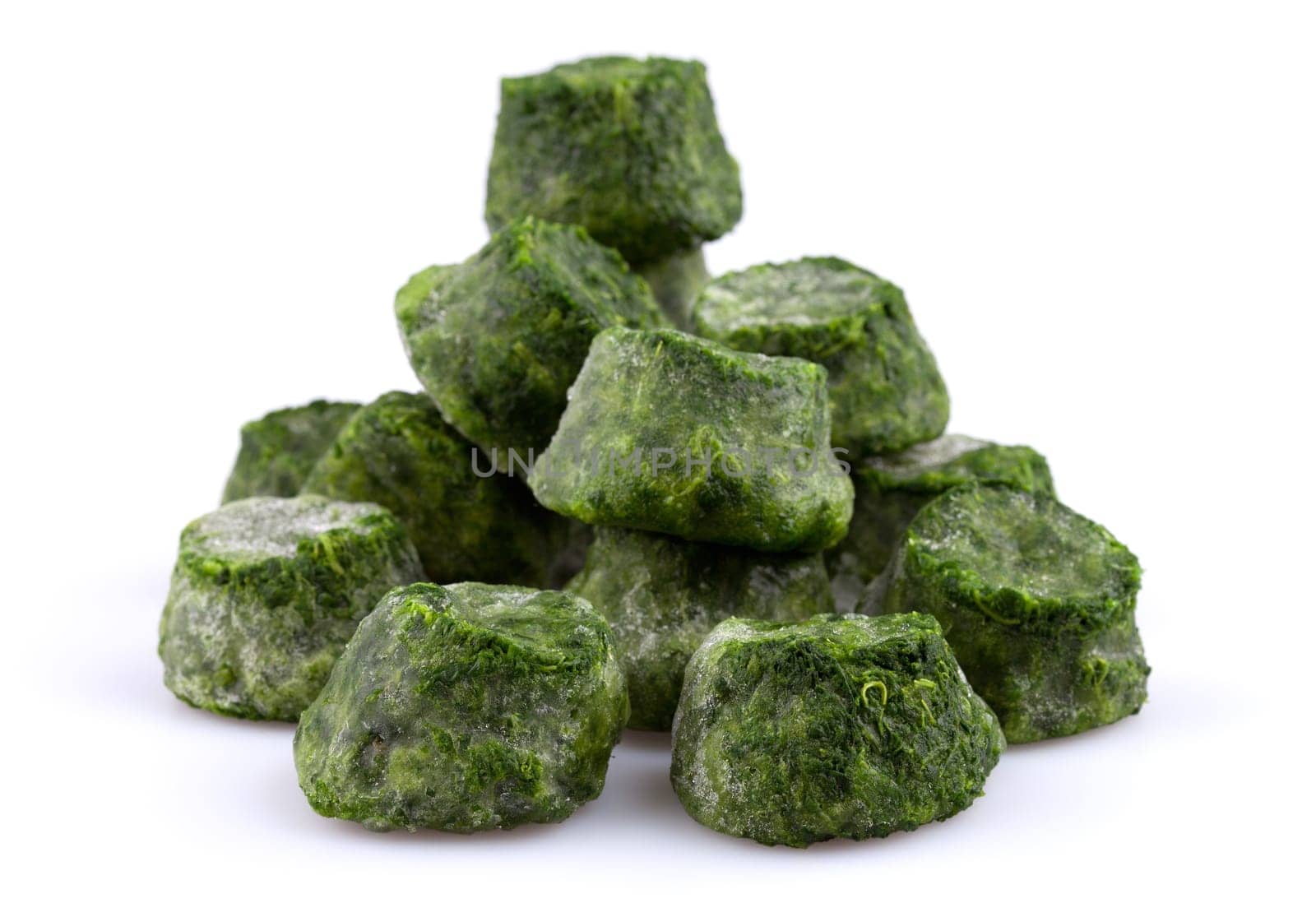 Frozen chopped spinach close-up isolated on white background.