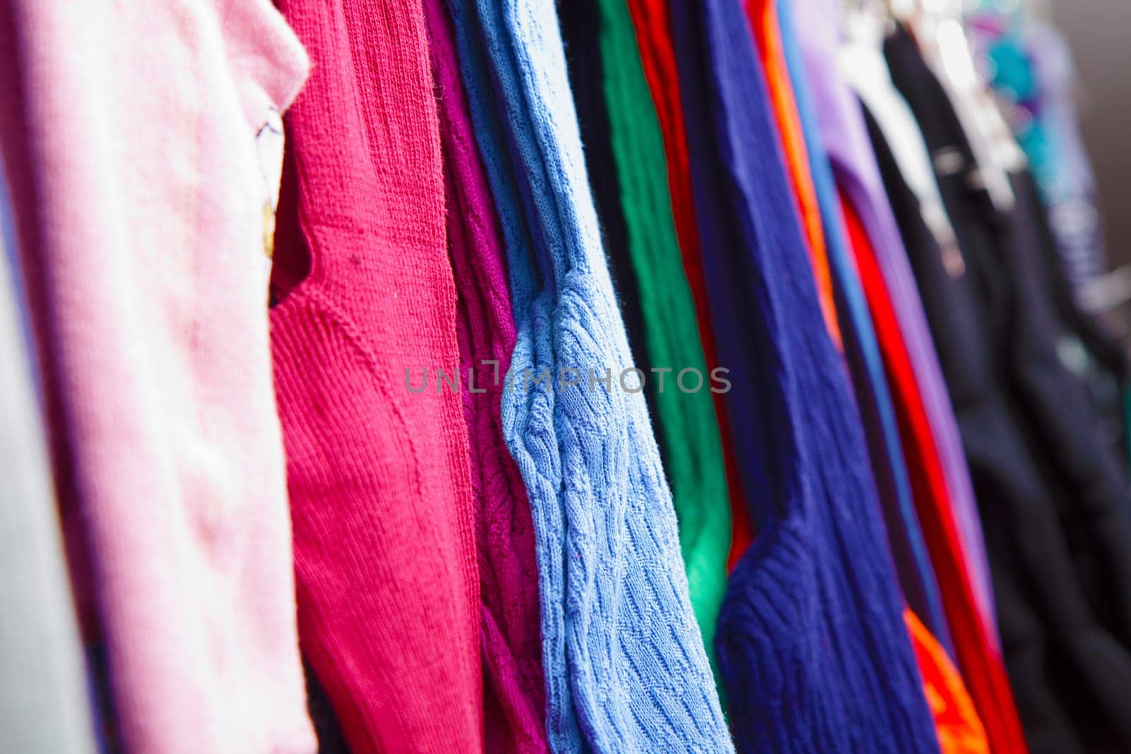 a lot of bright children's clothing on a hanger in the store