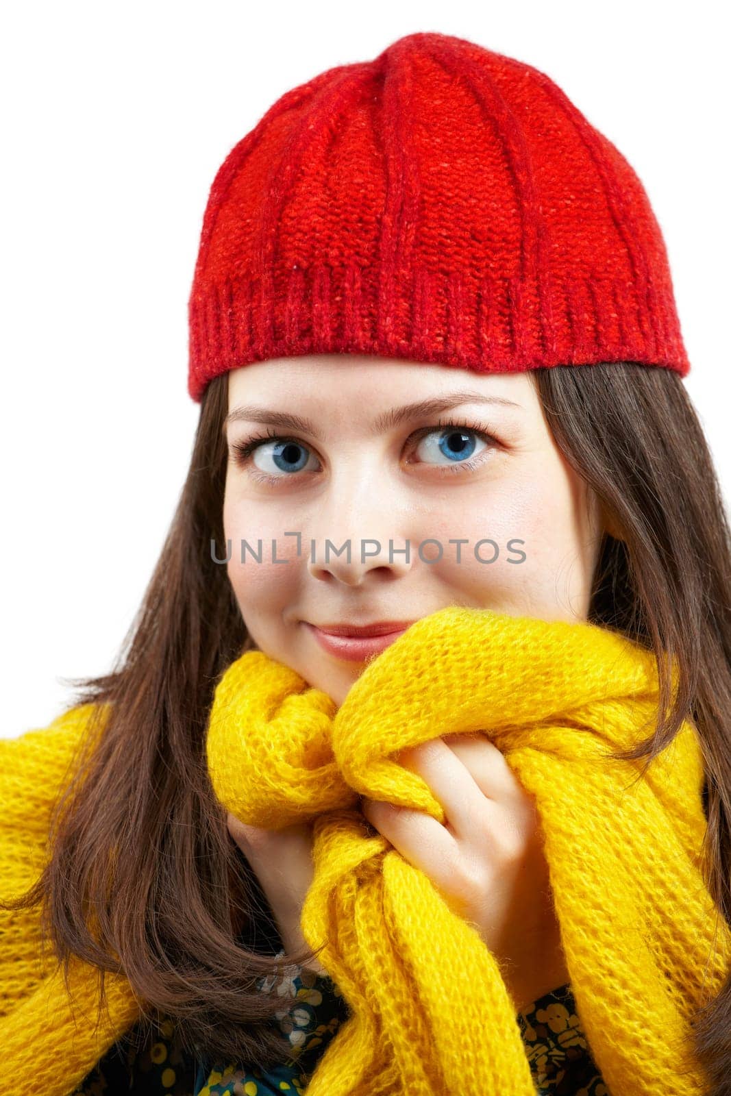 Portrait of a beautiful young woman with yellow scarf and red hat over white.