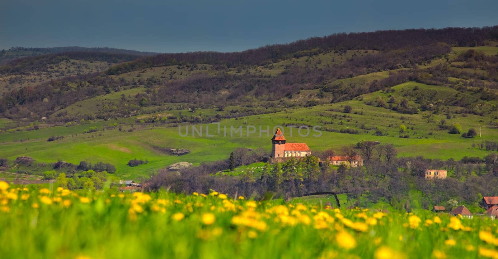 Overcast landscape over the Transylvanian village of Rodbav with the church on the hill, Romania.