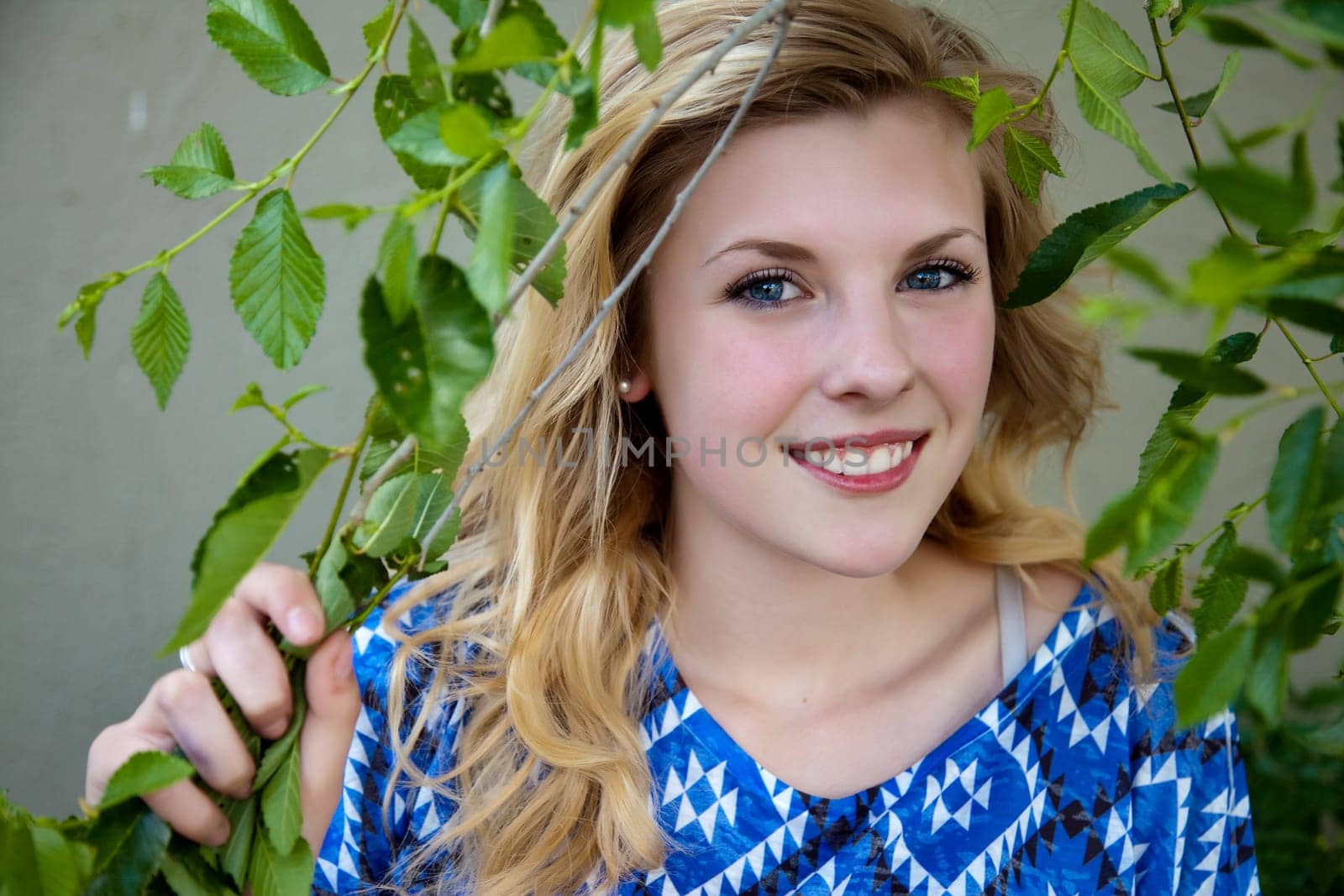 Outdoor photo of young, pretty, blonde girl in foliage