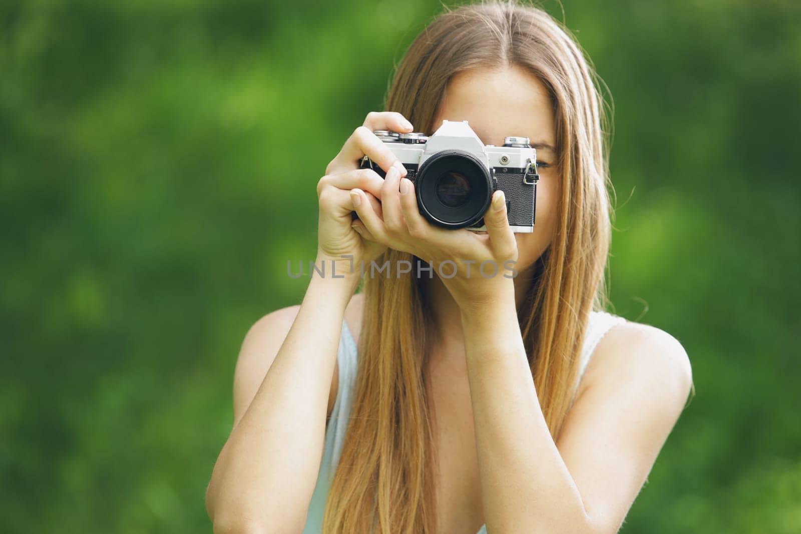 Young woman taking a picture with an old camera