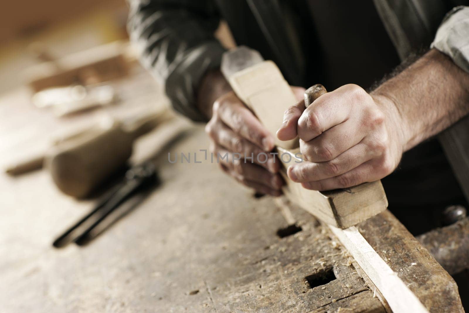 Hands of a carpenter planed wood, workplace