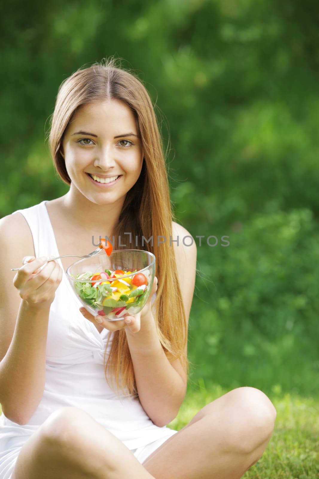 Portrait of young happy woman eating salad