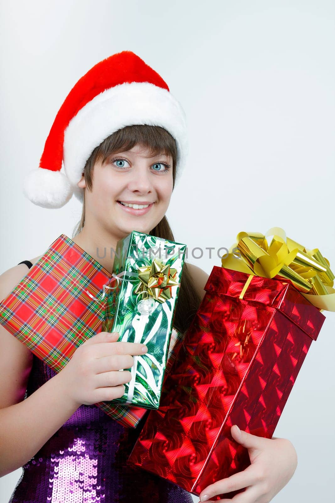 attractive girl in a Christmas hat with a bunch of gift boxes