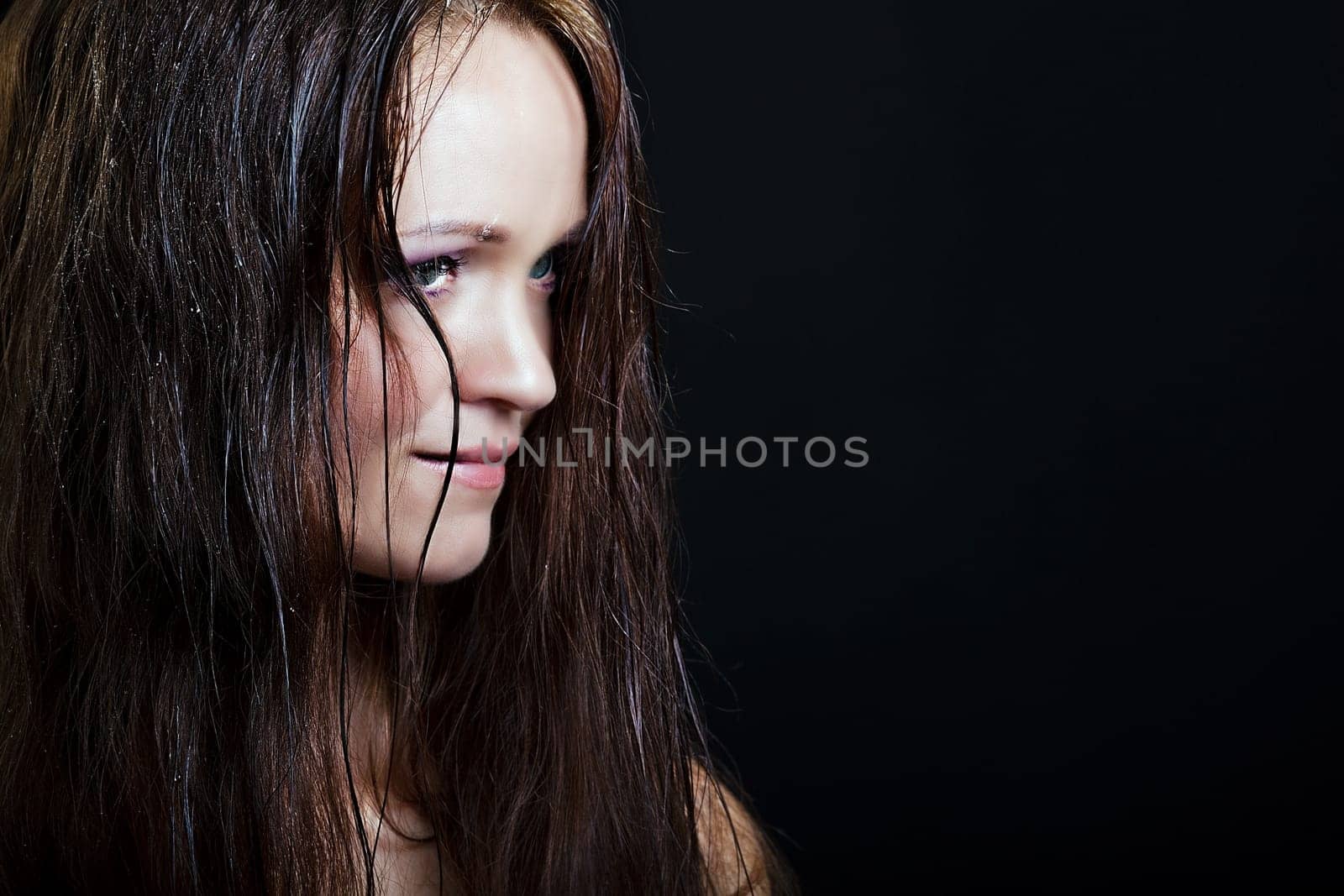beautiful girl with long wet hair on a black background