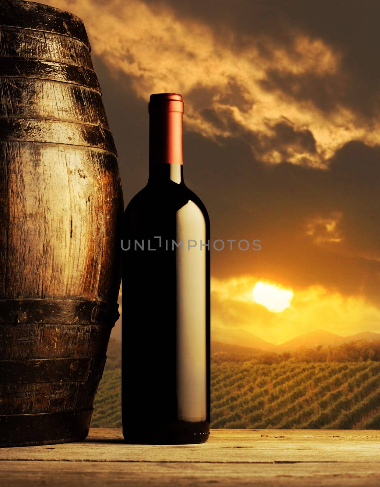 red wine bottle and wodden barrel, vineyard on background