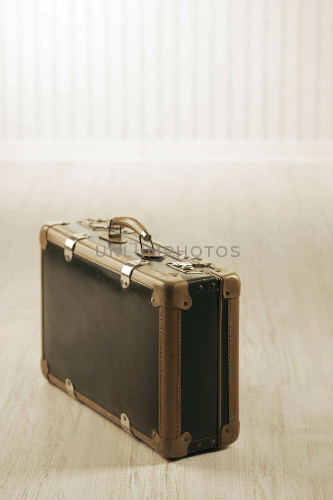 Old-fashioned suitcase alone in a room or station.