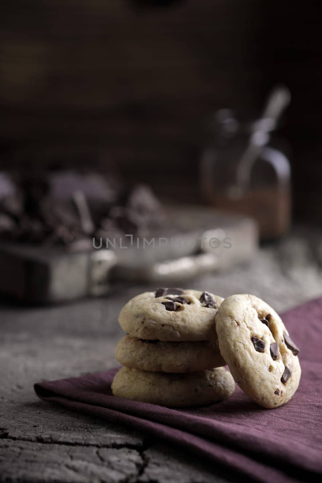 Stack of chocolate chip cookies with ingredients in the background