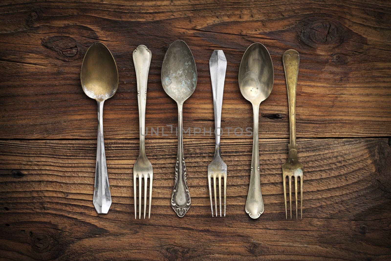 Old forks and spoons on wooden background